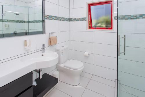 a bathroom with a toilet and a sink and a mirror at Kaikoura TOP 10 Holiday Park in Kaikoura