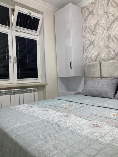 a bedroom with a large bed and two windows at AZERBAYCAN in Sumqayıt