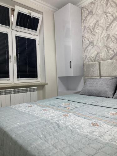 a bedroom with a large bed and two windows at AZERBAYCAN in Sumqayyt