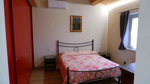 a bedroom with a bed with a red comforter at La Casetta in Petriolo