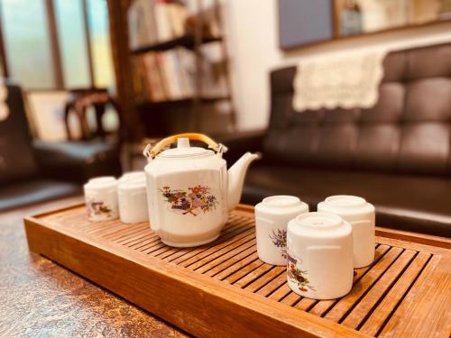 a tea pot and cups on a wooden tray at 1969 - Elixir of Love in Tainan