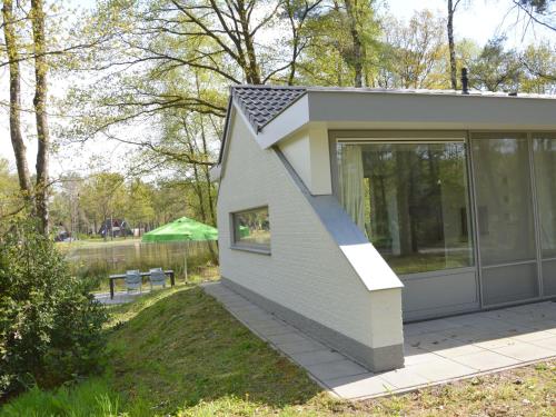 a small house with a roof on a patio at Alluring Holiday Home in Limburg near Forest in De Horst