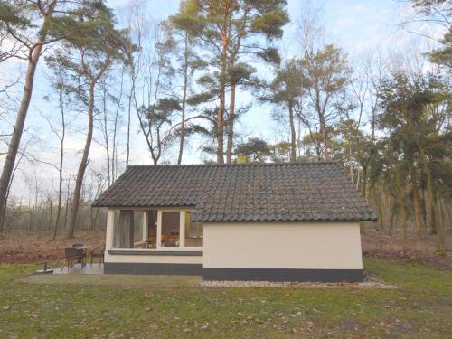 una pequeña casa en medio de un campo en Completely detached bungalow in a nature filled park by a large fen, en Stramproy