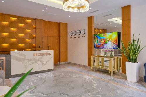 een hotellobby met een receptie en een televisie bij STYLO Residences & Suites in Tasjkent