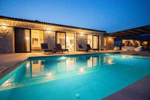 una piscina frente a una casa por la noche en Villa Margarita, en Katelios