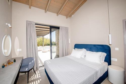 een slaapkamer met een bed, een bureau en een raam bij Villa Margarita in Kateliós