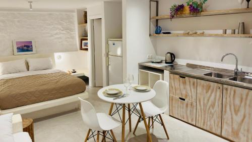 a small room with a bed and a kitchen with a table at Mykonos Tourlos Nests - Sea View Escape in Tourlos