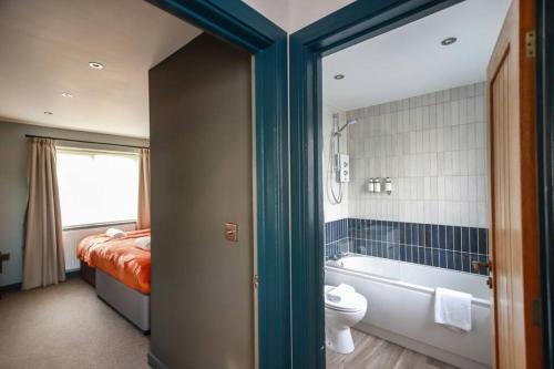 a bathroom with a bed and a tub and a toilet at May Disc - Long Stay - Contractors in Bristol
