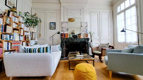 un salon avec deux canapés et une cheminée dans l'établissement Appartement tout confort, jardin, dans un Manoir au Sud de Tours, à Chambray-lès-Tours