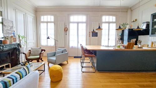 a living room with a kitchen with a table and chairs at Un séjour au Manoir sud Tours in Chambray-lès-Tours