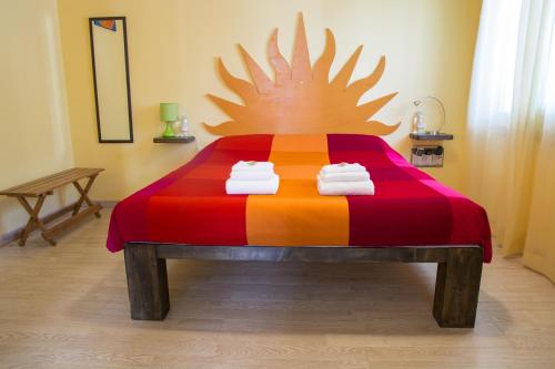 ein Schlafzimmer mit einem farbenfrohen Bett mit Handtüchern darauf in der Unterkunft B&B San Leone in San Leone