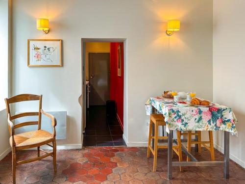 une cuisine avec une table et des chaises ainsi qu'une porte rouge dans l'établissement Studio cosy au cœur de Paris, à Paris
