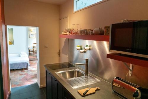 une cuisine avec un évier et une télévision sur un comptoir dans l'établissement Studio cosy au cœur de Paris, à Paris