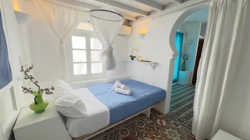 a small bedroom with a bed and a window at Mykonos Tourlos Nests - Sea View Escape in Tourlos