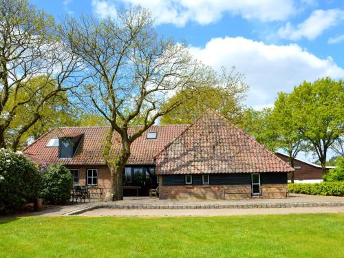 a house with a large roof on a green yard at Atmospheric country house in Asten on a golf course in Asten
