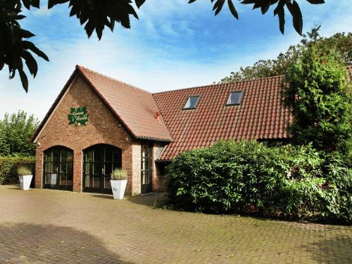 a large brick building with a red roof at Atmospheric country house in Asten on a golf course in Asten