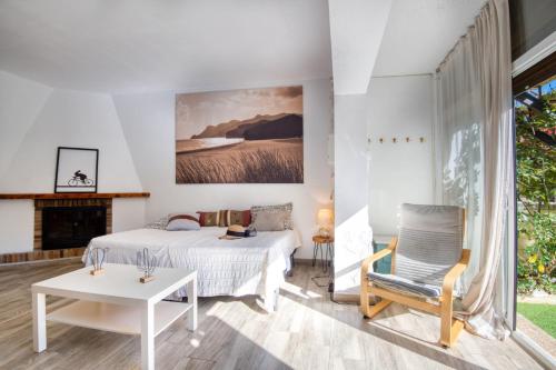 sypialnia z łóżkiem, krzesłem i kominkiem w obiekcie Dora w mieście L'Escala