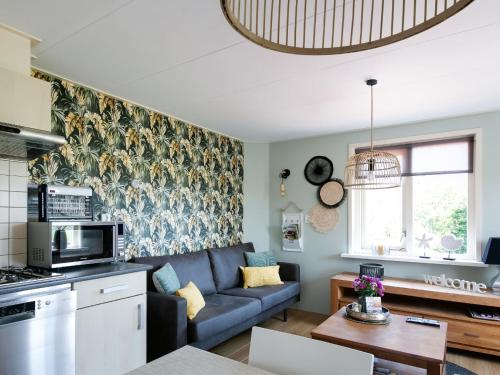 ein Wohnzimmer mit einem blauen Sofa und einer Küche in der Unterkunft Beautiful Apartment in Callantsoog near Beach in Callantsoog