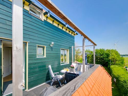 ein blaues Haus mit einem Tisch und Stühlen auf einer Terrasse in der Unterkunft Beautiful Apartment in Callantsoog near Beach in Callantsoog