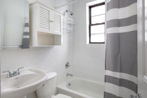 a white bathroom with a sink and a toilet at West Village 1br w wd nr bars restaurants NYC-1133 in New York