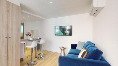 ein Wohnzimmer mit einem blauen Sofa und einem Tisch in der Unterkunft Résidence de l'ancien relais in Colmar