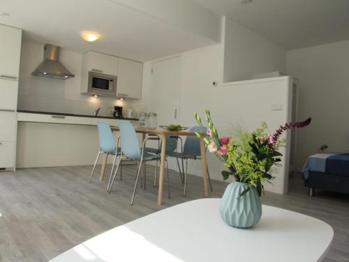 een keuken en een woonkamer met een tafel en stoelen bij Stunning apartment in Schoorl North Holland you can bike to the beach in Schoorl