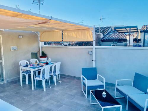 een patio met een tafel en stoelen en een parasol bij Royal House in Catania