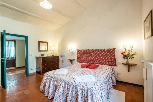 een slaapkamer met een bed met een rode en witte sprei bij Casalino in Castelnuovo Berardenga