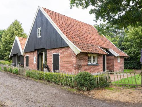 een rood bakstenen huis met een zwart dak bij Cozy Apartment in Enschede near Forest in Enschede