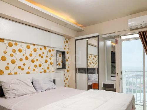 een slaapkamer met een wit bed en een groot raam bij RedLiving Apartemen Bogor Valley - Paulina Property Tower A in Kalibata 1