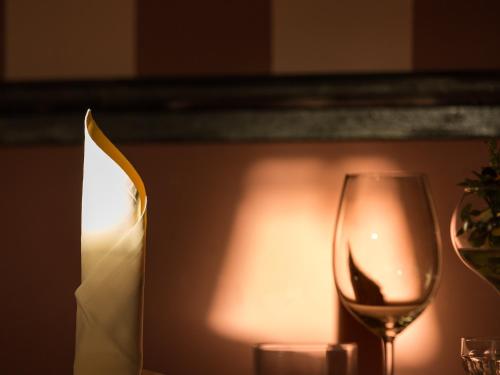 a candle and a wine glass on a table at Rooms & Restaurant Ostarija in Dolenjske Toplice