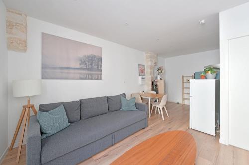 un salon avec un canapé gris et une table dans l'établissement Studio Arthur - Proche Théatres et Place des corps saints - WIFI, à Avignon