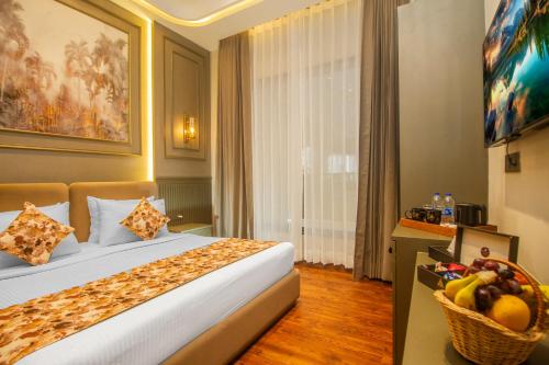 a hotel room with a bed and a basket of fruit at Amritara Maa Katra in Katra