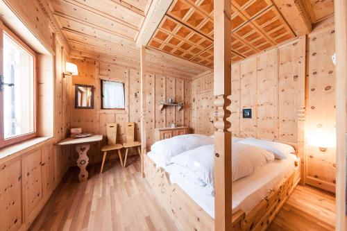 ein Schlafzimmer mit einem Bett in einer Holzhütte in der Unterkunft Chalet am Reschensee in Reschen