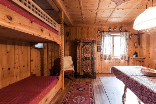 a bedroom with a bunk bed in a wooden room at Chalet am Reschensee in Resia