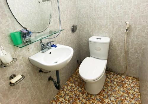 uma casa de banho com um WC, um lavatório e um espelho. em Coto Plus Hotel & Restaurant em Quang Ninh