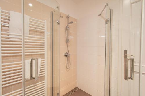 a bathroom with a shower and a glass at The Saddlers House - best price per bed in Bowmore