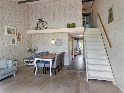 a kitchen and dining room with a staircase and a dining table at Beautiful holiday home in Horssen at the farm with a garden in Horssen