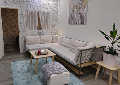 ein Wohnzimmer mit einem weißen Sofa und einem Tisch in der Unterkunft Karlabacken in Porvoo