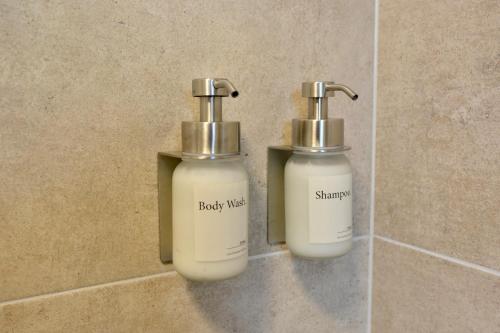 dos botellas de jabón en una pared en un baño en Business Living Oberkochen, en Oberkochen