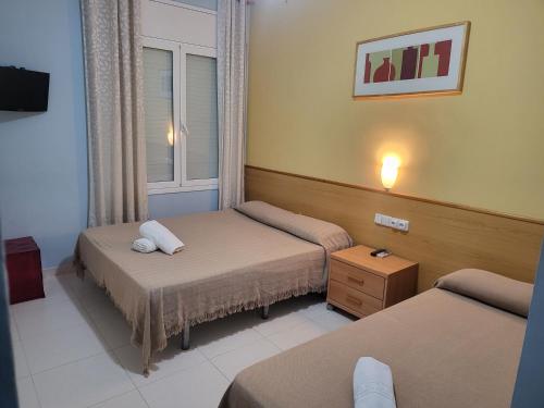 pokój hotelowy z 2 łóżkami i oknem w obiekcie Hotel Sant Jordi w mieście Segur de Calafell
