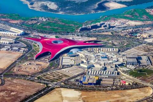 an aerial view of a city with a large red building at Lusy's studio Family Park in Abu Dhabi