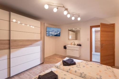 - une chambre avec un lit et un lavabo dans l'établissement Apartments Gondelspaß, à Fügen