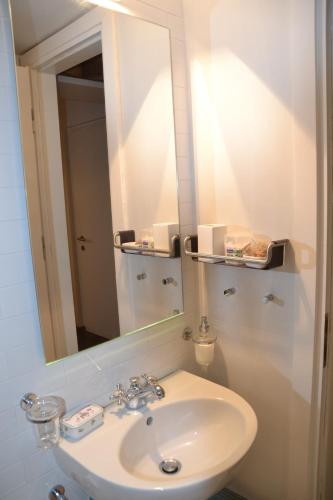 a bathroom with a sink and a mirror at Vouliagmeni seaside flat in Athens