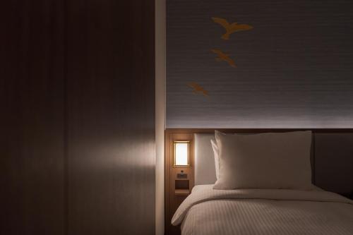 a bedroom with a bed with birds on the wall at Premier hotel -CABIN PRESIDENT- Tokyo in Tokyo