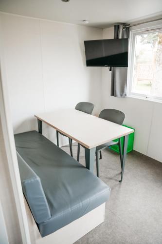 a dining room with a table and chairs in a room at Cahita Camping Belle-Vue 2000 in Berdorf