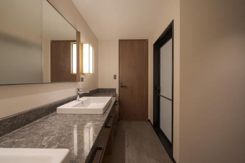 a bathroom with two sinks and a mirror at Premier hotel -CABIN PRESIDENT- Tokyo in Tokyo