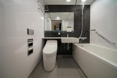 a bathroom with a toilet and a sink and a tub at Premier hotel -CABIN PRESIDENT- Tokyo in Tokyo