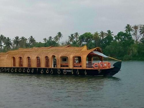a house boat with a roof on the water at Alleppy Whitefort Homestay Dulux Rooms -HouseBoat Available in Alleppey