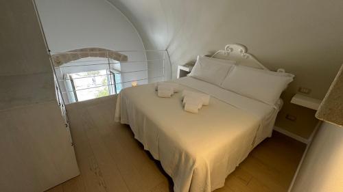 a bedroom with a white bed with two towels on it at Residenza Garibaldi in Monopoli